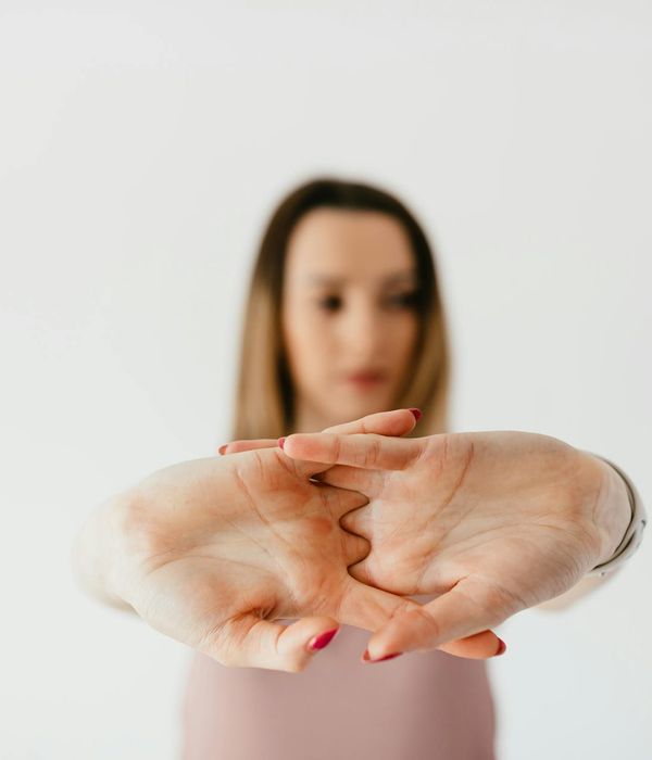 Woman performing a gentle yoga stretch in a modern office.